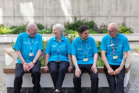 Colin Dutton seated alongside other volunteers in the hospital