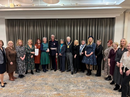 Sunshine Group members stand proudly, smiling, with the King’s Award for Voluntary Services, alongside His Majesty’s Lord-Lieutenant for Merseyside, Mr Mark FW Blundell, Lord Mayor of Liverpool, Councillor Richard Kemp CBE and Lady Mayoress of Liverpool, Alderwoman Erica Kemp CBE.