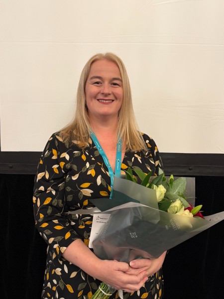 Rachel Quinn holding flowers during her award presentation at Bowel Cancer UK Awards