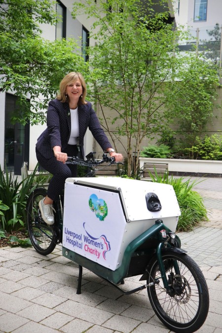 Minister for Local Transport Lilian Greenwood, sat on a bike in a garden area at the Royal.