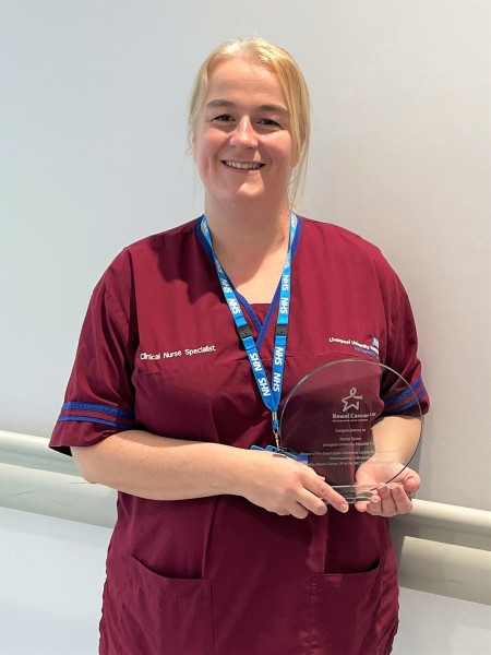 Rachel Quinn in colorectal nurse uniform with her Bowel Cancer UK award.jpg
